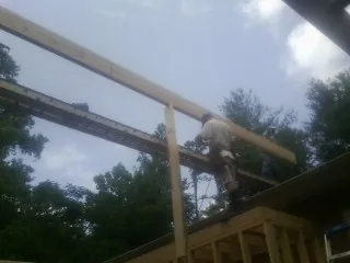 Carpenter setting a ridge beam over a new addition frame — Ice Dam Removal by Roofing Brothers in Monroe Township