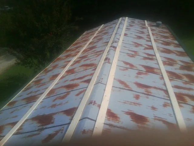 Rusted metal roof panels with new wood purlins before replacement — Storm Damage Roof Repair in Monroe Township by Roofing Brothers