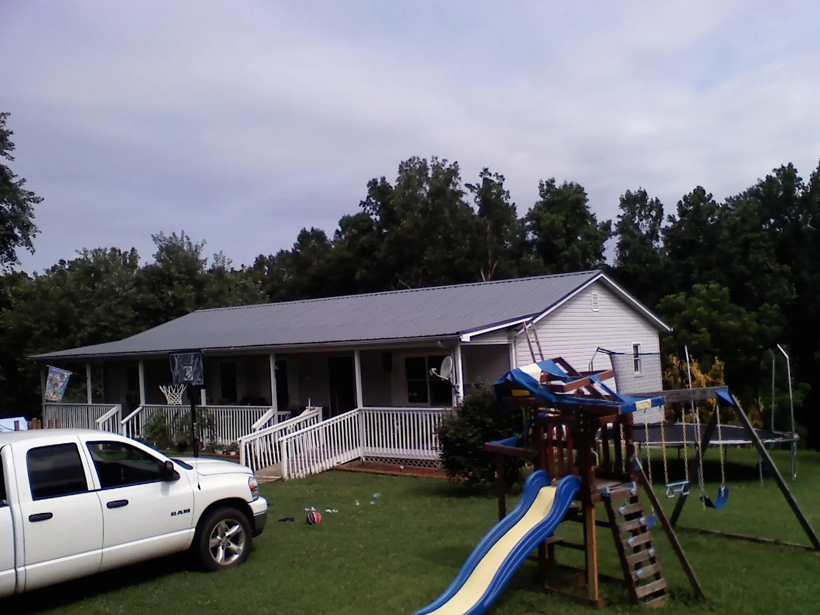 Dark metal roof on a country home with a full length front porch in Monroe Township