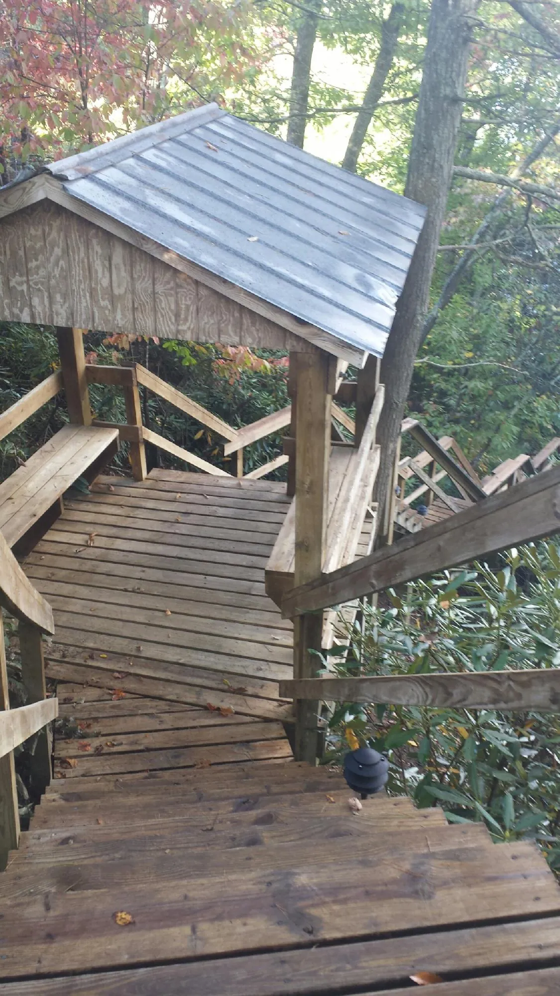 Metal roofed shelter over wooden steps on a wooded walkway — Skylight Repair & Installation work by our crew in Monroe Township