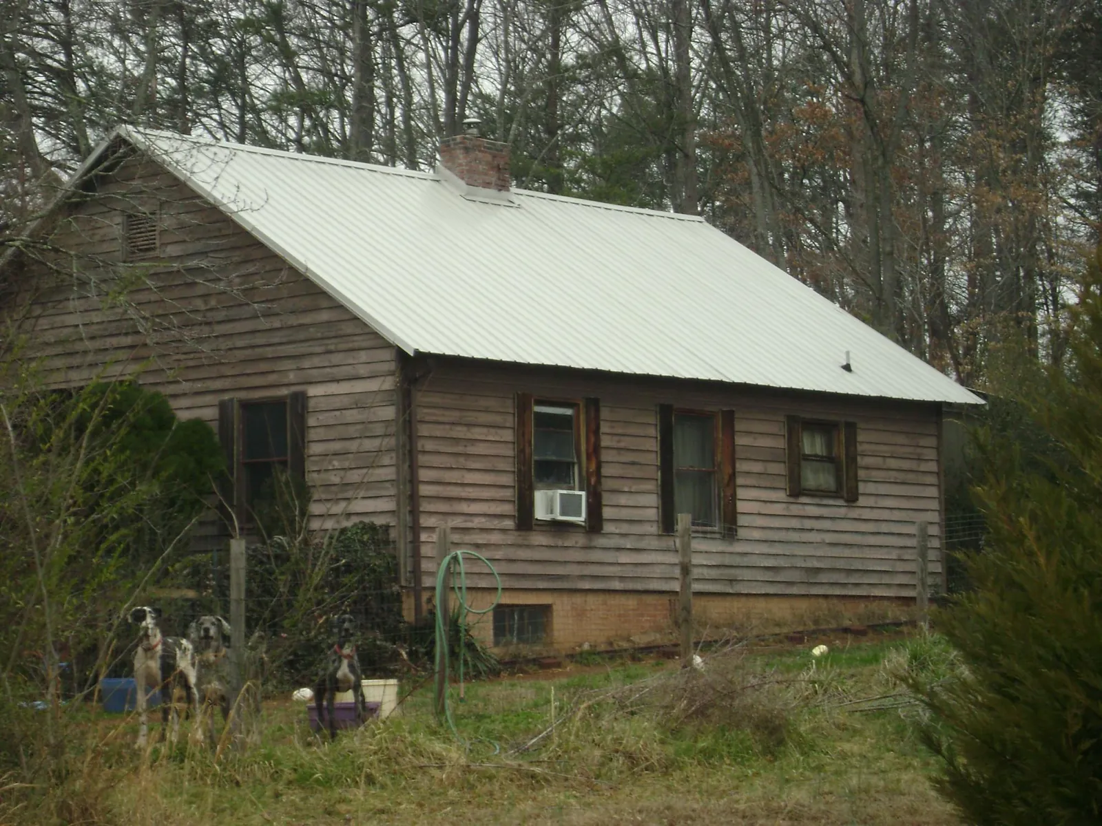 White metal roof on an old wood sided farmhouse, from a Metal Roof Installation job in Monroe Township